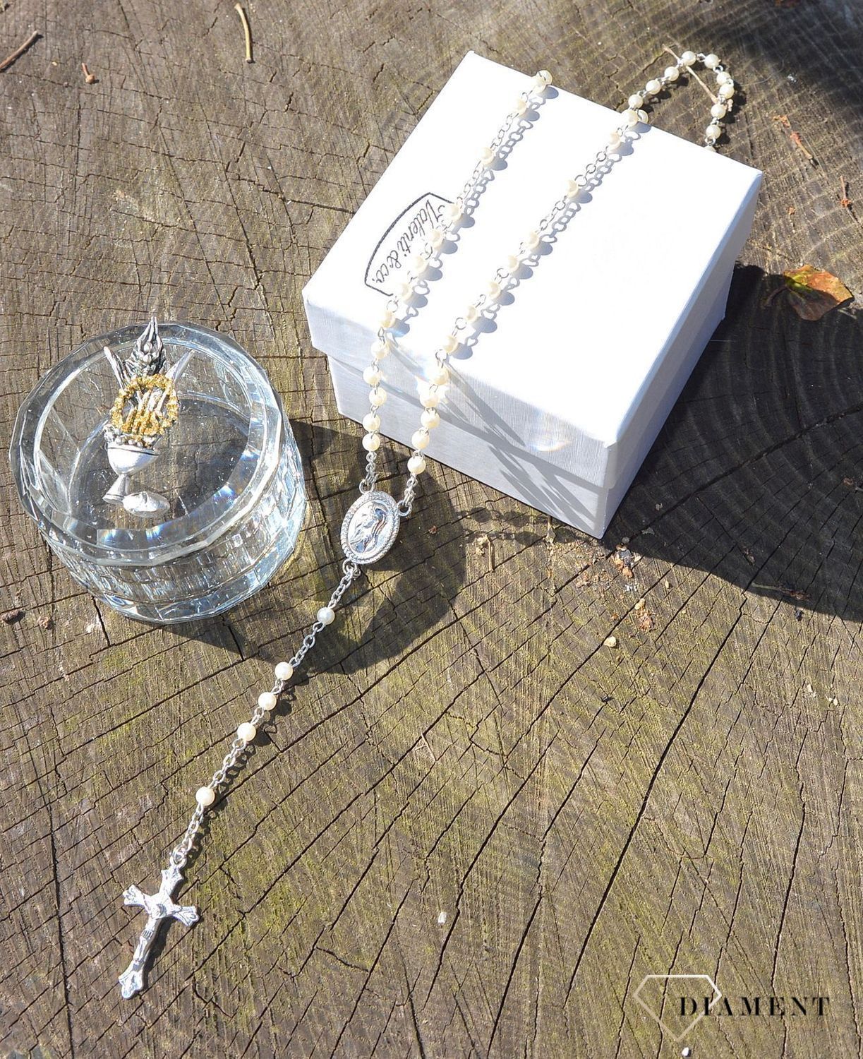 Różaniec komunijny z koralików w kolorze perłowym. Umieszczony w pięknie zdobionym szklanym opakowaniu. Na pokrywce starannie wykonany symbol komunijny - Hostia (1).JPG